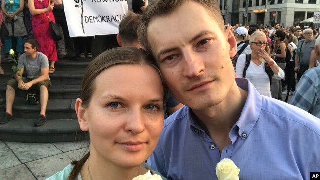 FILE - Ukrainian activist Lyudmyla Kozlovska (L), and her husband Bartosz Kramek are seen during an anti-government protest in Warsaw, Poland, Aug. 10, 2017.