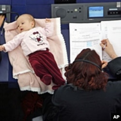 Denmark's member of the European Parliament Hanne Dahl (R) takes part with her baby in a voting session at the European Parliament in Strasbourg March 26, 2009
