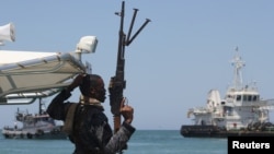 FILE - A maritime policeman on a tag-boat guards oil tanker Aris-13, which was released by pirates, as it sails to dock on the shores of the Gulf of Aden in the city of Bosasso, northern Somalia's semi-autonomous region of Puntland, March 19, 2017. 