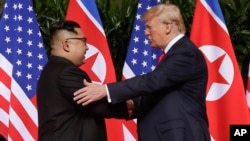 FILE - U. S. President Donald Trump shakes hands with North Korea leader Kim Jong Un at the Capella resort on Sentosa Island, June 12, 2018 in Singapore.
