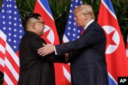 FILE - U. S. President Donald Trump shakes hands with North Korea leader Kim Jong Un at the Capella resort on Sentosa Island, June 12, 2018 in Singapore.