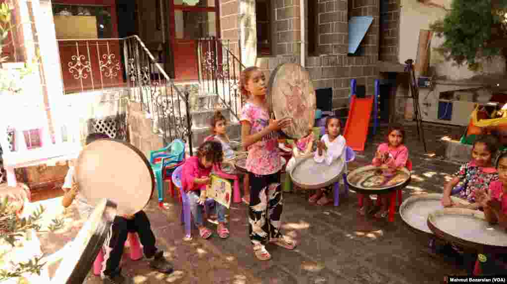 Bir grup çocuk, arbane adı verilen yerel bir müzik enstrümanı eşliğinde şarkı söylüyor.