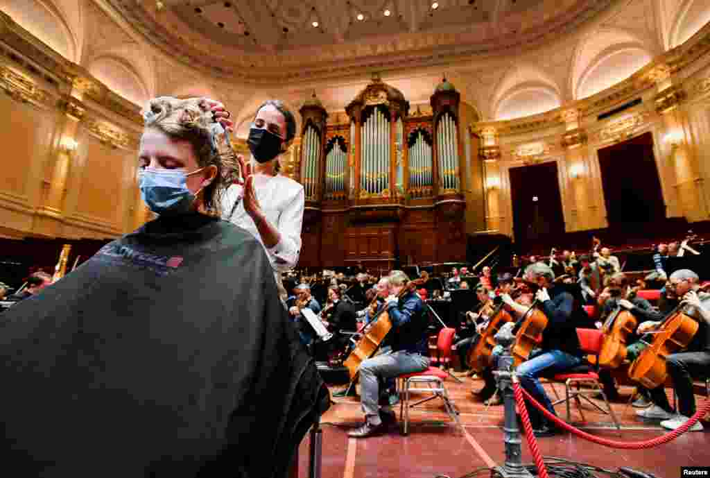 A customer gets a haircut at a concert hall as employees at museums and concert halls protest against government rules that allow gyms and hairdressers to re-open while they have to stay shut because of COVID-19 restrictions, in Amsterdam, Netherlands.
