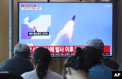 People watch a TV showing file footage of North Korea's missile launch during a news program at the Seoul Railway Station in Seoul, South Korea, Thursday, May 9, 2019.