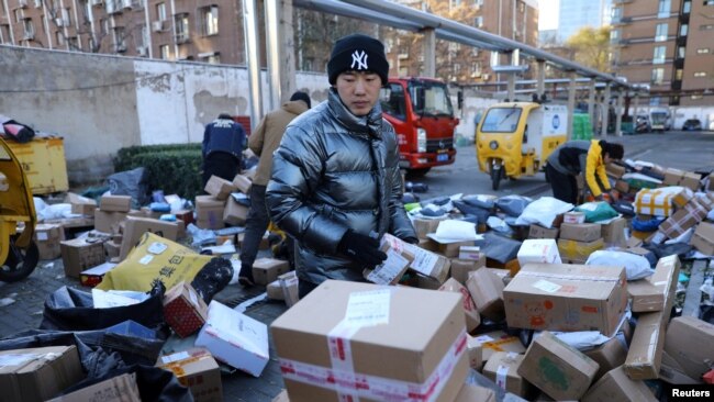 Delivery workers sort parcels at a makeshift logistics station near the Central Business District during Singles’ Day shopping festival in Beijing, China November 11, 2021.