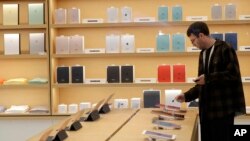 FILE - A shopper looks at iPad tablets displayed at a store on Apple's campus before an announcement of new products, Oct. 27, 2016, in Cupertino, California.