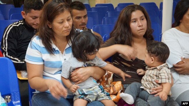 Madres con hijos esperan ser asistidas por voluntario en un centro humanitario en McAllen, Texas, en la frontera con México. Junio 15, 2018.