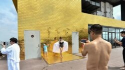 Les clients posent pour des photos à la piscine du tout nouvel hôtel Dolce Hanoi Golden Lake, le premier hôtel plaqué or au monde, à Hanoi le 2 juillet 2020.