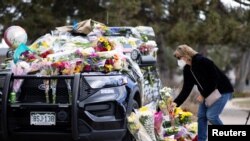 Karla Bielanski places flowers on the car of Officer Eric Talley, who was killed yesterday during a mass shooting in King Soopers grocery store, at Boulder Police Department, in Boulder, Colorado, U.S., March 23, 2021.