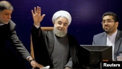 Iranian President Hassan Rouhani (C) waves after registering for February's election of the Assembly of Experts, at the Interior Ministry in Tehran, Dec. 21, 2015.