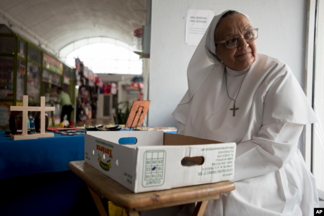 Sister Carmen Negrón, 64, sells handmade rosaries and religious icons in the Plaza del Mercado in San Juan, Puerto Rico, April 17, 2019. Negrón says she's noticed a drop in sales because of what seems to be fewer people in the area.