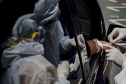 Para petugas medis mengambil sampel darah dalam lantatur tes cepat di tengah wabah virus corona (COVID-19) di Bandung, Jawa Barat, 4 April 2020. (Foto: Antara via Reuters)