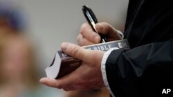 President Donald Trump, visiting areas in Alabama hit by severe storms, signs a Bible as he greets people at Providence Baptist Church in Smiths Station, Ala., March 8, 2019. 