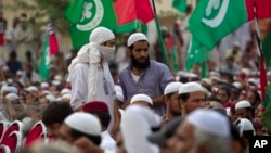 FILE - Supporters of banned sectarian group Sipah-e-Sahaba listen to their leaders at a gathering in Islamabad, Pakistan, Oct. 4, 2013. Pakistan's DAWN newspaper says that 41 of the 64 extremist organizations banned by the government operate freely online