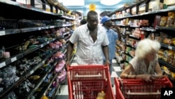 FILE - Customers shop at a Harare supermarket selling goods priced in foreign currency, Dec. 8, 2008. 