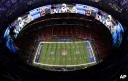 Players warm up ahead of the NFL Super Bowl football game between the Los Angeles Rams and the New England Patriots, Feb. 3, 2019, in Atlanta, Georgia.