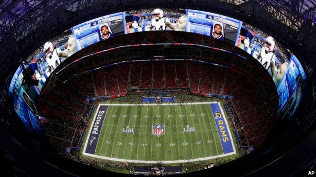 Players warm up ahead of the NFL Super Bowl football game between the Los Angeles Rams and the New England Patriots, Feb. 3, 2019, in Atlanta, Georgia.
