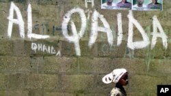 Arhiva - Devojčica prolazi pored zida na kome je grafit mreže Al Kaida, u Kanu, Nigerija, 18. aprila 2003. 