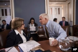 House Rules Committee Chairman Pete Sessions, R-Texas (C), confers with Rep. Louise Slaughter, D-N.Y., the top Democrat, as the panel meets on Capitol Hill in Washington, Dec. 21, 2017.