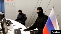 FILE - Members of Russia's FSB security service are seen during a raid in Moscow, Sept. 5, 2016.