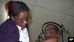 A nurse examines a patient suffering from Tuberculosis TB of the bones, cramped with metals to keep his bones tight, at Queen Elizabeth Central Hospital in Blantyre. (file photo)