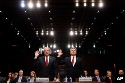 Department of Justice Inspector General Michael Horowitz, left, and FBI Director Christopher Wray are sworn in during a hearing of the Senate Judiciary Committee to examine Horowitz's report of the FBI's Clinton email probe, on Capitol Hill, June 18, 2018.