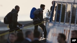 Migrants get on a ferry at the port of Mytilini in the Greek island of Lesbos, Monday, April 3, 2016. EU officials say they are trying to improve the process after angry protests by human rights activists.