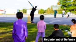 Afghan refugees play in an informal cricket match at Fort McCoy, Wisc., Sept. 29, 2021. The fort is one of several places in the US where Afghans receive temporary housing, medical screening, and general support following evacuation from Afghanistan.