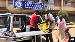 FILE: A family brings a sick relative to Parerenyatwa Hospital in Harare, Monday, Oct, 14, 2019.