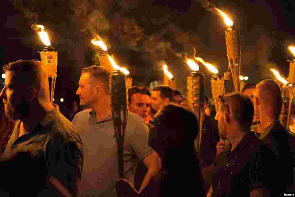White supremacists carry torches on the grounds of the University of Virginia, on the eve of a planned "Unite the Right" rally in Charlottesville, Virginia, Aug. 11, 2017.