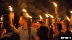 White supremacists carry torches on the grounds of the University of Virginia, on the eve of a planned "Unite the Right" rally in Charlottesville, Virginia, Aug. 11, 2017.