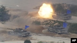 South Korean K1A1 battle tanks fire during the South Korea-U.S. joint military drills at Seungjin Fire Training Field in Pocheon, South Korea, near the border with North Korea, Friday, Aug. 28, 2015.