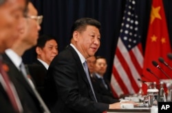 China's President Xi Jinping (center) speaks to U.S. President Barack Obama at their meeting during the Asia-Pacific Economic Cooperation in Lima, Peru, Nov. 19, 2016.