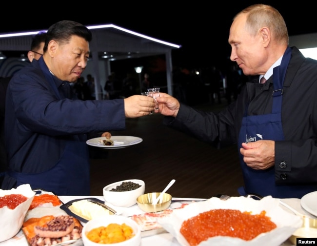 Russian President Vladimir Putin and Chinese President Xi Jinping toast during a visit to the Far East Street exhibition on the sidelines of the Eastern Economic Forum in Vladivostok, Russia September 11, 2018.