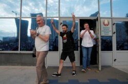 Employees of Belarusian National State TV and Radio Company leave the building and greet demonstrators during rally to protest against presidential election results.