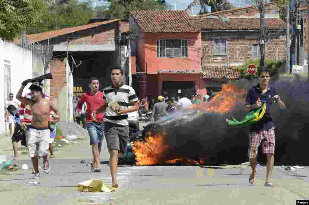 Demonstrators run after setting a vehicle on fire in Fortaleza, Brazil, June 19, 2013. 