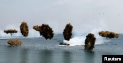 Amphibious assault vehicles of the South Korean Marine Corps throw smoke bombs during a U.S.-South Korea joint landing operation drill in Pohang, southeast of Seoul, during Foal Eagle exercises in 2013.