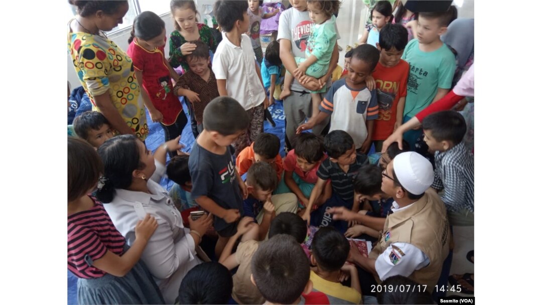 Pekerja sosial Dinas Sosial DKI Jakarta, Muhammad Kurniawan saat bermain bersama anak-anak di lobby bangunan bekas Kodim 0504 di Jakarta Barat, Rabu, 17 Juli 2019. (Foto: VOA/Sasmito)