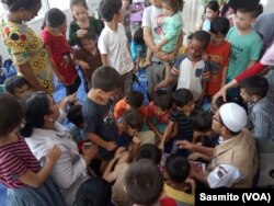 Pekerja sosial Dinas Sosial DKI Jakarta, Muhammad Kurniawan saat bermain bersama anak-anak di lobby bangunan bekas Kodim 0504 di Jakarta Barat, Rabu, 17 Juli 2019. (Foto: VOA/Sasmito)