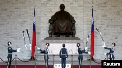 FILE - Honour guards perform in front of a statue of late Nationalist Generalissimo Chiang Kai-shek in Taipei, Feb. 7, 2007.