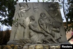 A relief sculpture depicts Father Junipero Serra with Native Americans at the Carmel Mission in Carmel, California, May 5, 2015.
