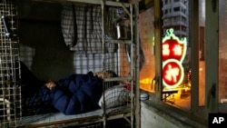 In this 2013 file photo, an elderly man sleeps in a small space he calls home in Hong Kong. The income gap in the territory has become an increasingly important issue. (AP Photo/Vincent Yu)