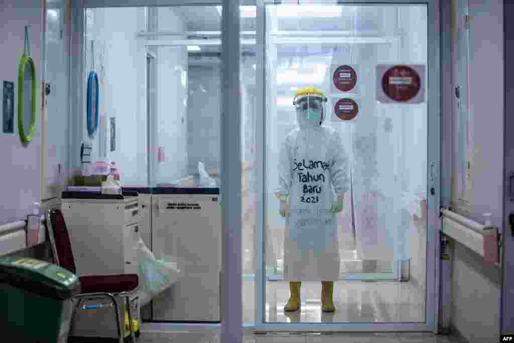 A medical staff wears personal protective equipment (PPE) with the words &quot;Happy New Year 2021&quot; to encourage COVID-19 coronavirus patients while working at the Bogor City Hospital in West Java.
