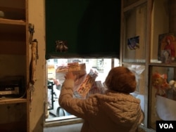 Volunteer receives bag of donations for those displaced from war-torn eastern Ukraine. (L. Ramirez/VOA)