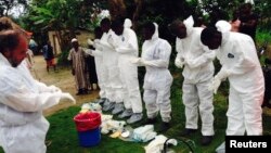 Volunteers prepare to remove the bodies of people who were suspected of contracting Ebola and died.