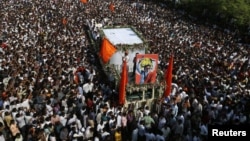 Supports of the Shiv Sena party crowd around the vehicle carrying the body of right-wing Hindu nationalist politician Bal Thackeray during his funeral procession in Mumbai, November 18, 2012. 