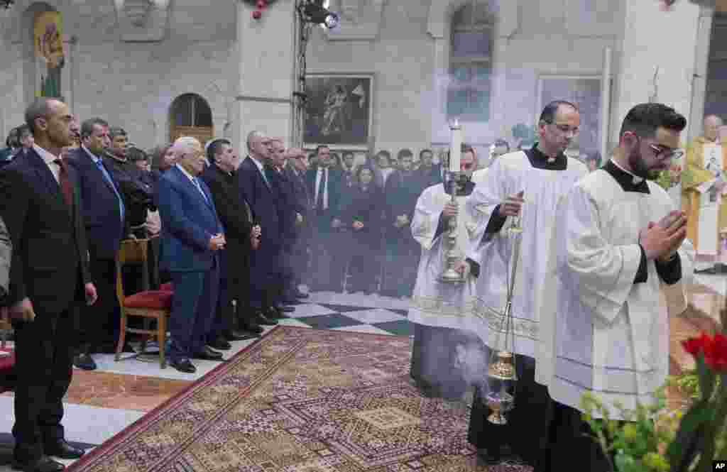 Palestinian President Mahmoud Abbas, second from left in front, attends a Christmas midnight mass at Saint Catherine&#39;s Church, in the Church of the Nativity, traditionally recognized by Christians to be the birthplace of Jesus Christ, in the West Bank city of Bethlehem, Dec. 25, 2018.