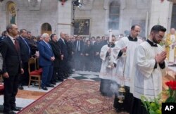 Palestinian President Mahmoud Abbas, second from left in front, attends a Christmas midnight mass at Saint Catherine's Church, in the Church of the Nativity, traditionally recognized by Christians to be the birthplace of Jesus Christ.