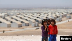 FILE - Syrian refugee children pose before the visit of actress Angelina Jolie to hold a news conference at Azraq refugee camp for Syrians displaced by conflict, near Al Azraq city, Jordan, Sept. 9, 2016. 