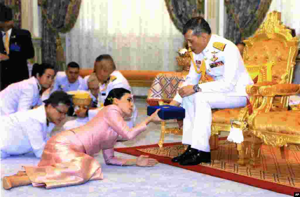 In this photo released by Bureau of the Royal Household ,Thailand&#39;s King Maha Vajiralongkorn Bodindradebayavarangkun, right, presents a gift to Queen Suthida Vajiralongkorn Na Ayudhya at Ampornsan Throne Hall in Bangkok. An announcement in the Royal Gazette said Suthida Vajiralongkorn Na Ayudhya is legally married to the 66-year-old king, and is now Queen Suthida.